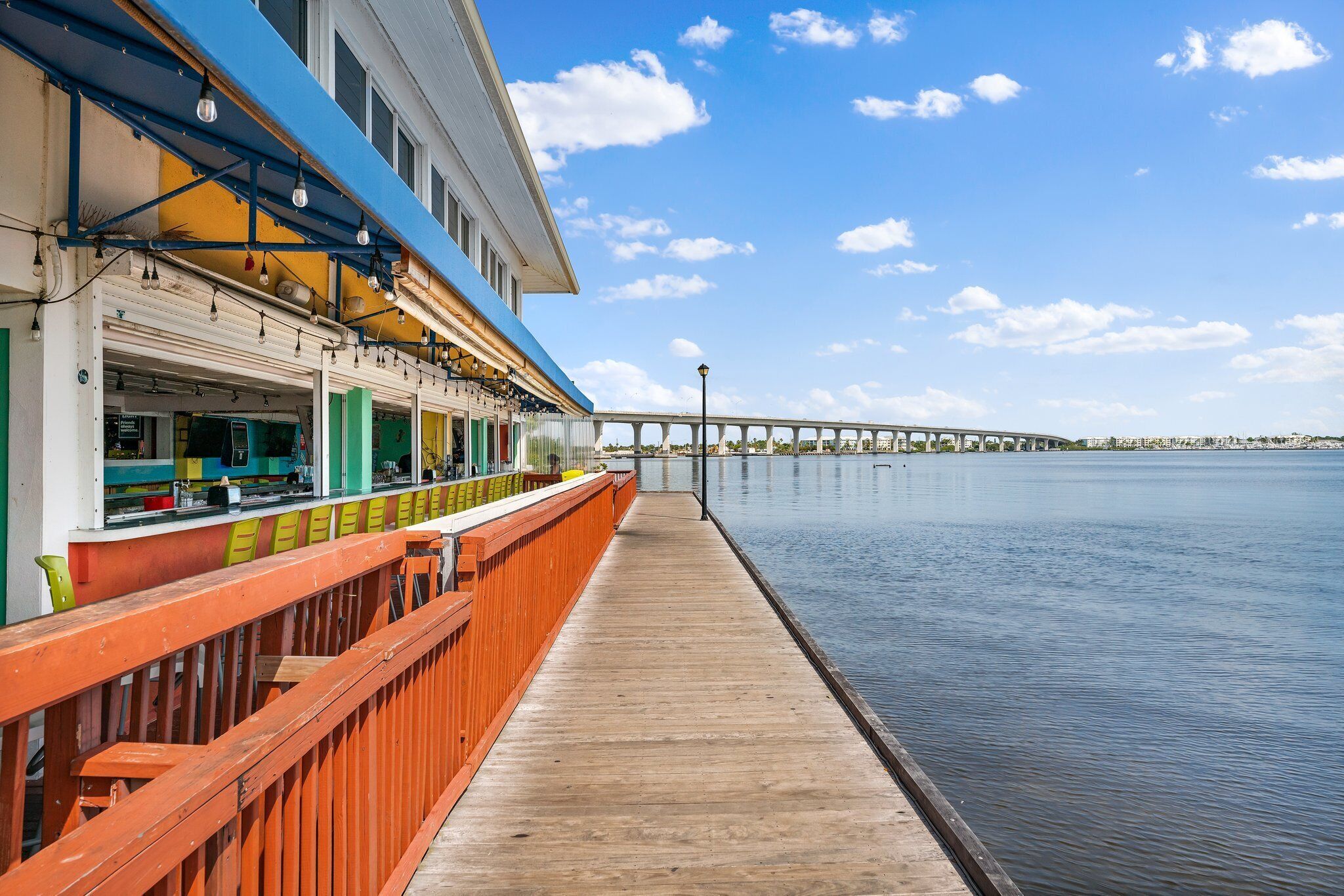 Un restaurante frente al agua, con terraza de madera y vista al mar.