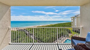 A balcony with a view of the ocean, a pool, and a staircase leading to a lower level. - Oceanfront Condo Located in Paradise on S. Hutchinson Island/Stuart 
 (Stuart)