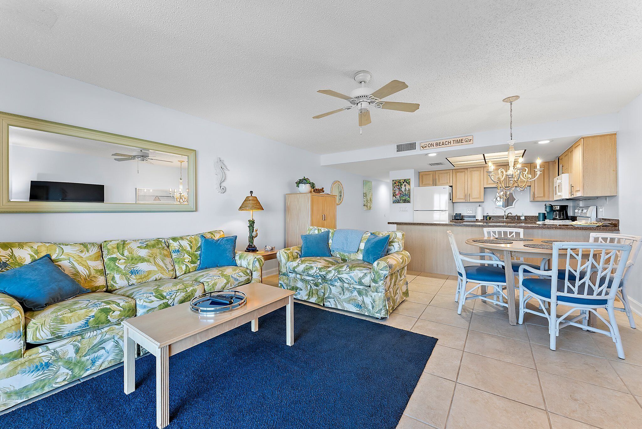 A living room with a sofa, coffee table, and dining area with chairs.