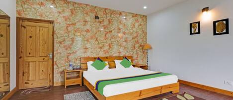 Ein Schlafzimmer mit einem hölzernen Bett, einem Nachttisch, einem Holzschrank und floralem Wandpapier.