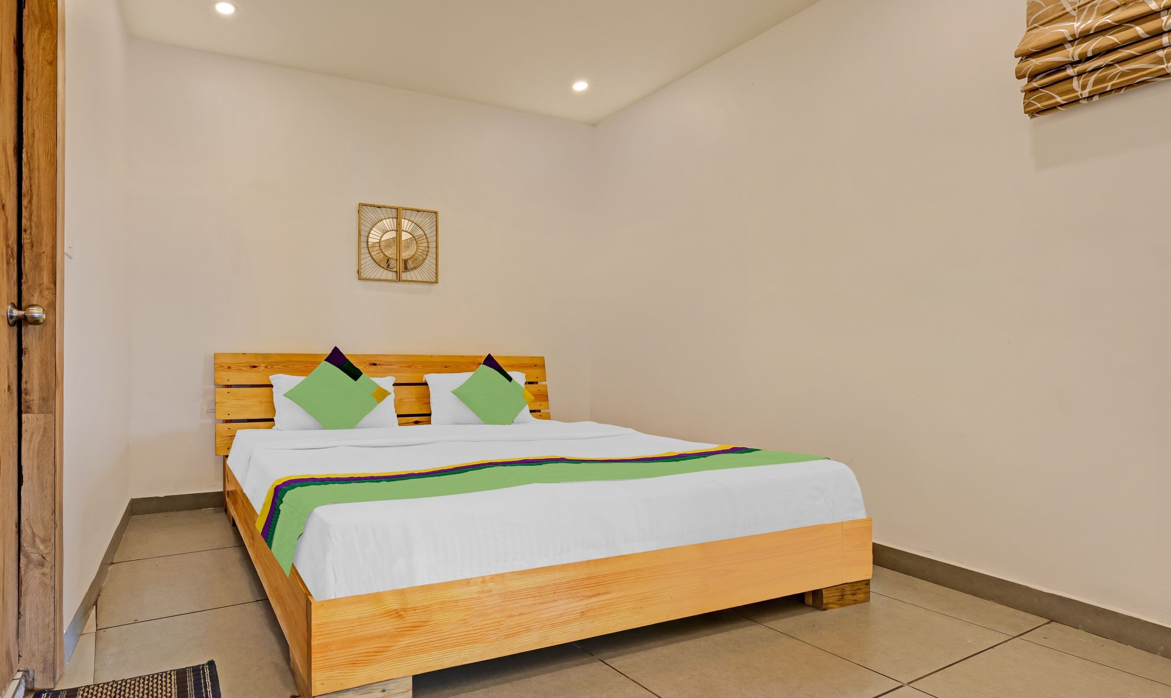 A neatly made bed with a wooden frame and a colorful bedspread.