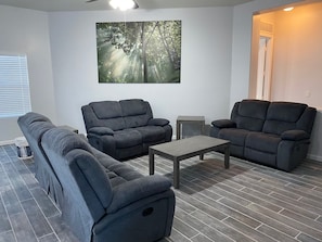 A modern living room with a sectional sofa, two armchairs, and a coffee table.