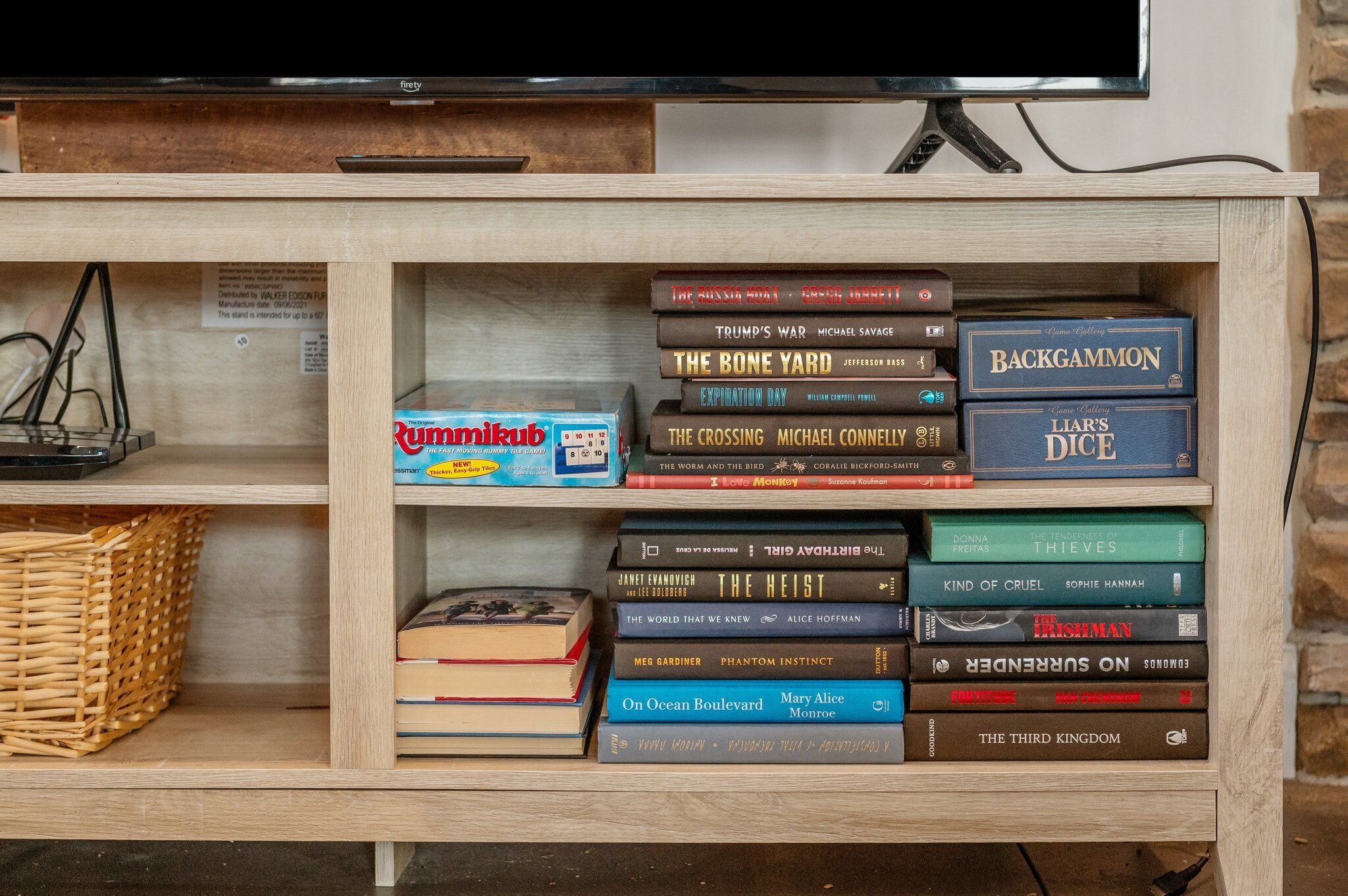 A wooden bookshelf with various books and board games.
