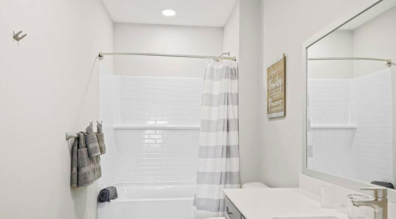 A modern bathroom with a bathtub, toilet, and sink.
