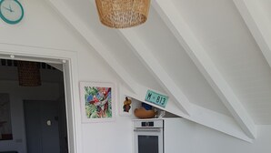 A dining area with a wooden table, white chairs, and a ceiling fan.