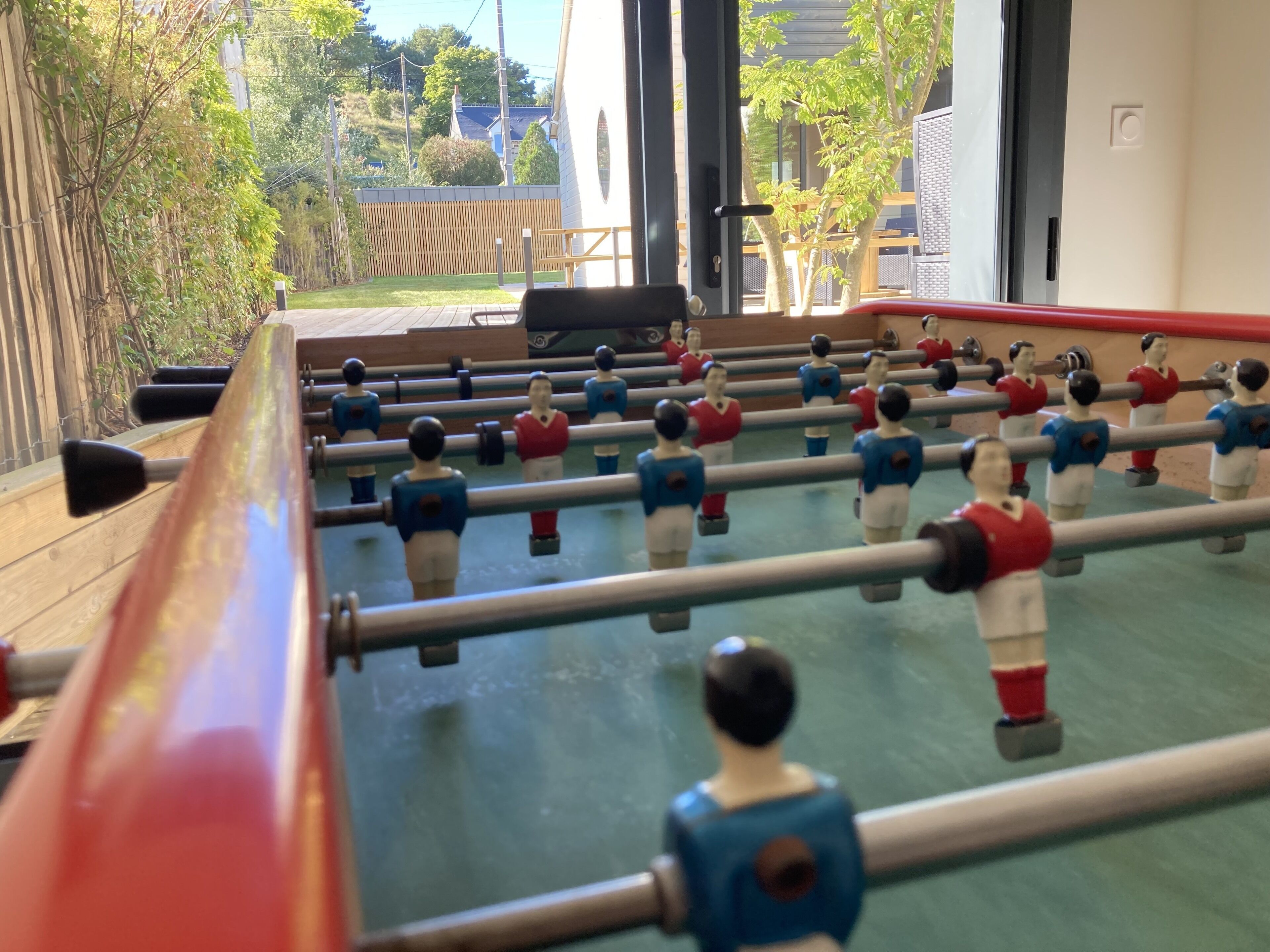 A foosball table with players in red and blue uniforms.