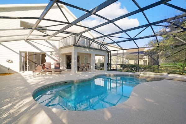 Relax by the pool surrounded by a glass enclosure and lounge chairs in a contemporary space.