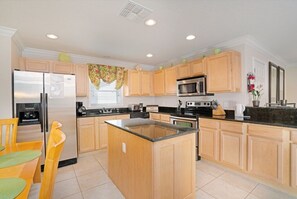 Enjoy cooking in this well-equipped kitchen with a central island, stainless steel appliances, and ample counter space.