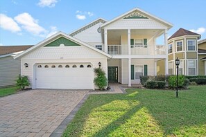 Stunning two-story home with a front porch and balcony, perfect for relaxing.
