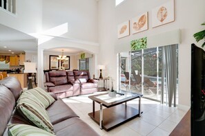 Relax in a spacious living room with a large leather sofa, sleek coffee table, and comfortable armchair.