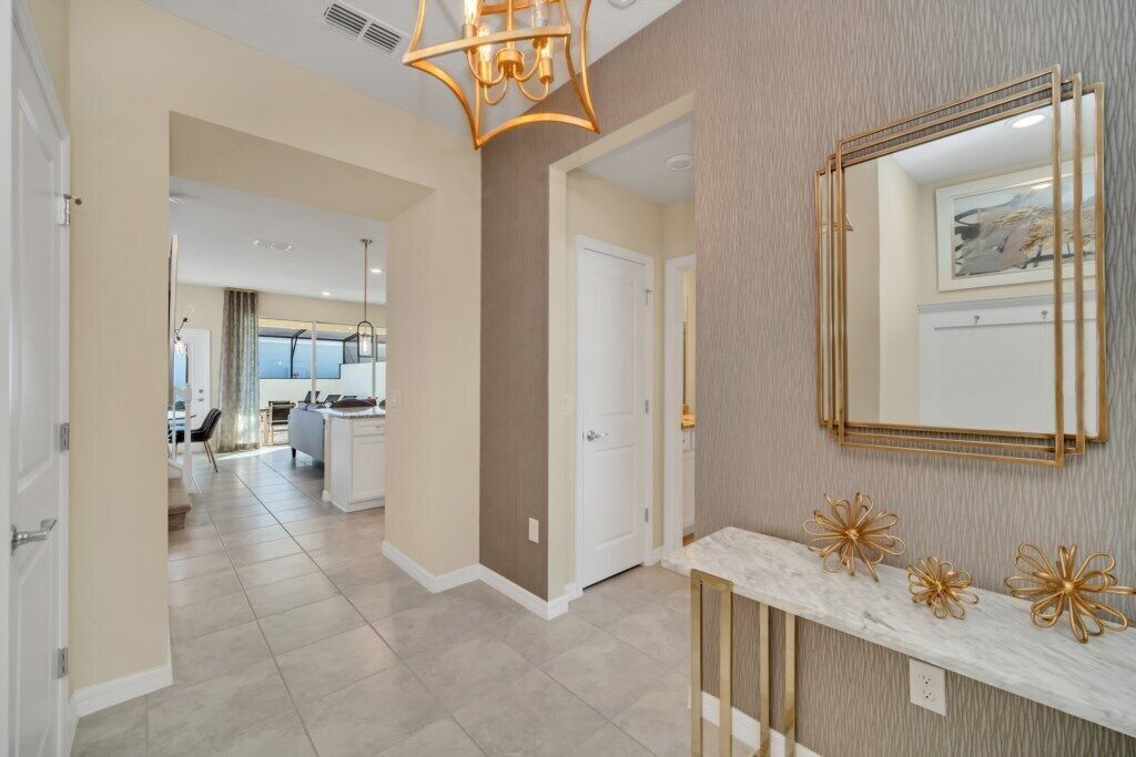 A modern hallway with a marble console table, gold decorative elements, and a large mirror.