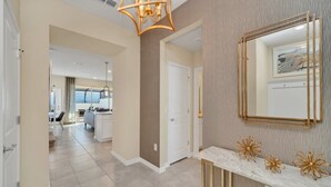 A modern hallway with a marble console table, gold decorative elements, and a large mirror.