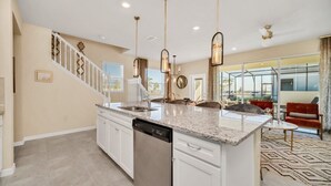 A spacious kitchen with a large island, white cabinetry, and stainless steel appliances.