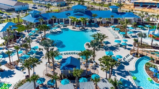 A resort with multiple swimming pools, palm trees, and lounge areas.