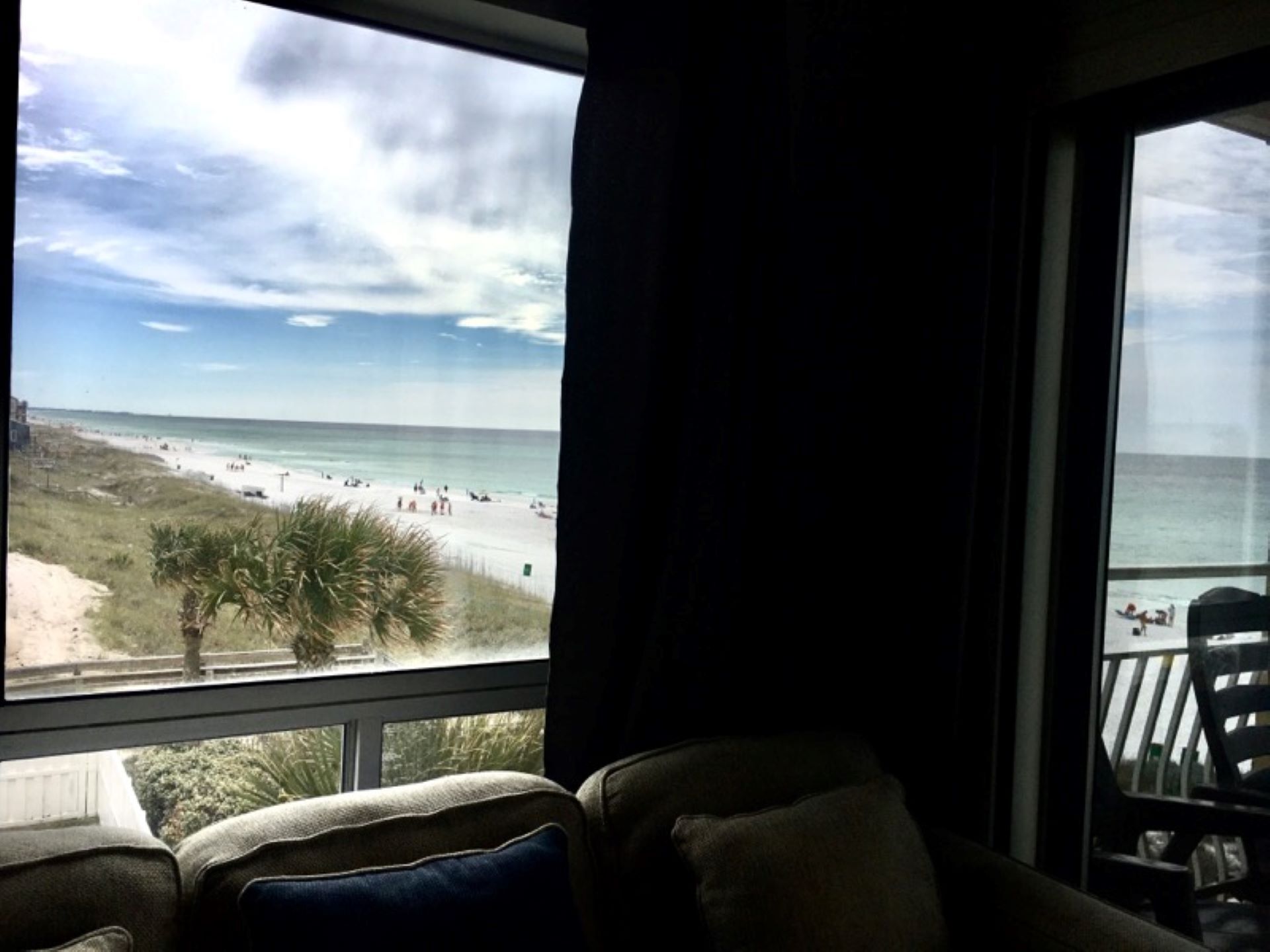 A room with a large window overlooking a beach.