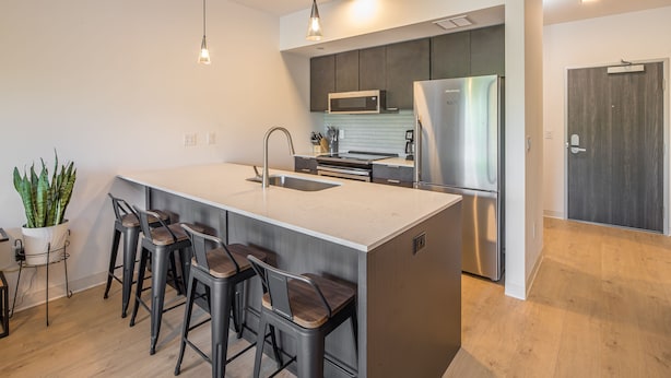 A modern kitchen with a large island, stainless steel appliances, and bar stools. - Modern condo in Downtown Bozeman w/private balcony, private parking, and AC - SOBO Urban Oasis (Bozeman)