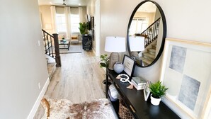 A hallway with a cowhide rug, a console table with a mirror, and framed artwork on the wall. - Ocotillo Springs 49| Private Heated Pool & Spa | 5 Bedroom & 5.5 Bath (SANTA CLARA)