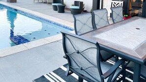 A poolside area with a covered patio, outdoor seating, and a view of the surrounding landscape. - Ocotillo Springs 49| Private Heated Pool & Spa | 5 Bedroom & 5.5 Bath (SANTA CLARA)