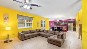 Relax in this spacious living area with a large L-shaped sofa, dining space, and kitchenette.