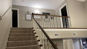 Una escalera con barandilla de madera que sube a un segundo piso.