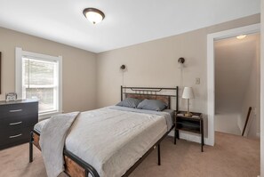 A bedroom with a bed, nightstand, dresser, and a window with blinds. - NEWLY REMODLED 3BD Home Walk To ProMedica Hospital (Toledo)
