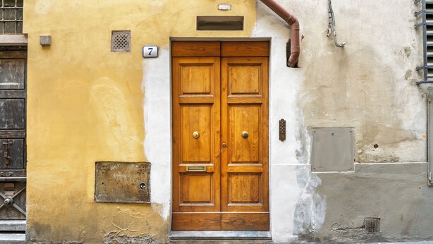 A double wooden door with a number plate '7' above it, set in a building with a yellow and white facade. - Inferno Double - One Bedroom Apartment, Sleeps 2 (Firenze)