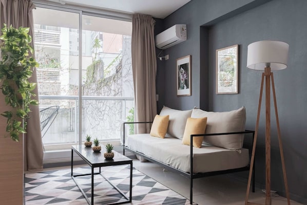 A modern living room with a sofa, a coffee table, and a floor lamp.