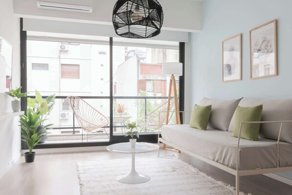 A modern living room with a sofa, a round table, and a hanging chair.