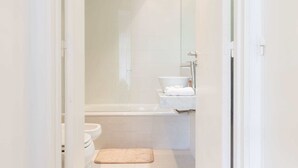 Une salle de bain équipée d’une baignoire, de toilettes et d’un espace douche.