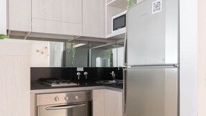 A modern kitchen with stainless steel appliances, a microwave, and a refrigerator.