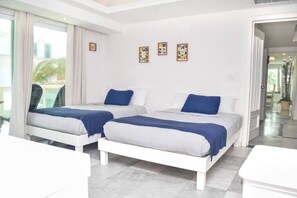 A hotel room with two beds, a large window, and artwork on the wall. - Cancun Beach 3 Brms apartment, great area, stunning beach (Cancún)
