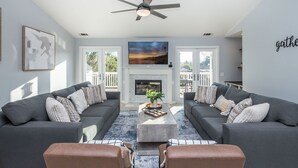 A modern living room with two grey sofas, a coffee table, and a ceiling fan. - The Ultimate Family Getaway- Game Room/Pool/Hot Tub/Human Chess! (Escondido)