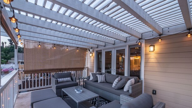 An outdoor patio with wicker furniture, string lights, and a pergola. - The Ultimate Family Getaway- Game Room/Pool/Hot Tub/Human Chess! (Escondido)