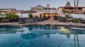 A pool area with a patio, outdoor seating, and a two-story building with a balcony. - The Ultimate Family Getaway- Game Room/Pool/Hot Tub/Human Chess! (Escondido)