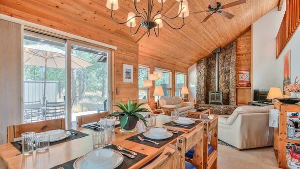 Un intérieur en bois comprenant un coin repas, un salon et un mur en pierre.