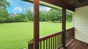 A covered porch with a view of a well-maintained lawn and trees. - Relax at The Blue Bird - 2BD/2BA + Easy Parking (Good Hope)