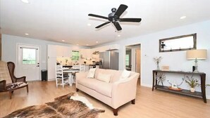 A spacious living room with a beige sofa, a wooden coffee table, and a large rug. - Relax at The Blue Bird - 2BD/2BA + Easy Parking (Good Hope)