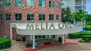 A building with a curved facade and the name "MELIA ORLAND" prominently displayed. - Pet Friendly in Orlando area near Disney (Celebration)