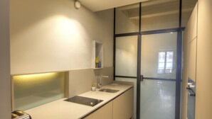 A modern kitchen with a marble floor, built-in cabinets, a stainless steel sink, and recessed ceiling lights. - Charming & traditional apartment in Valletta ESCH2 (Valletta)