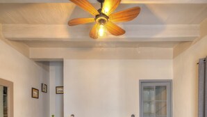 A hotel room with a large bed, a ceiling fan, a staircase, and a door. - Charming & traditional apartment in Valletta ESCH2 (Valletta)