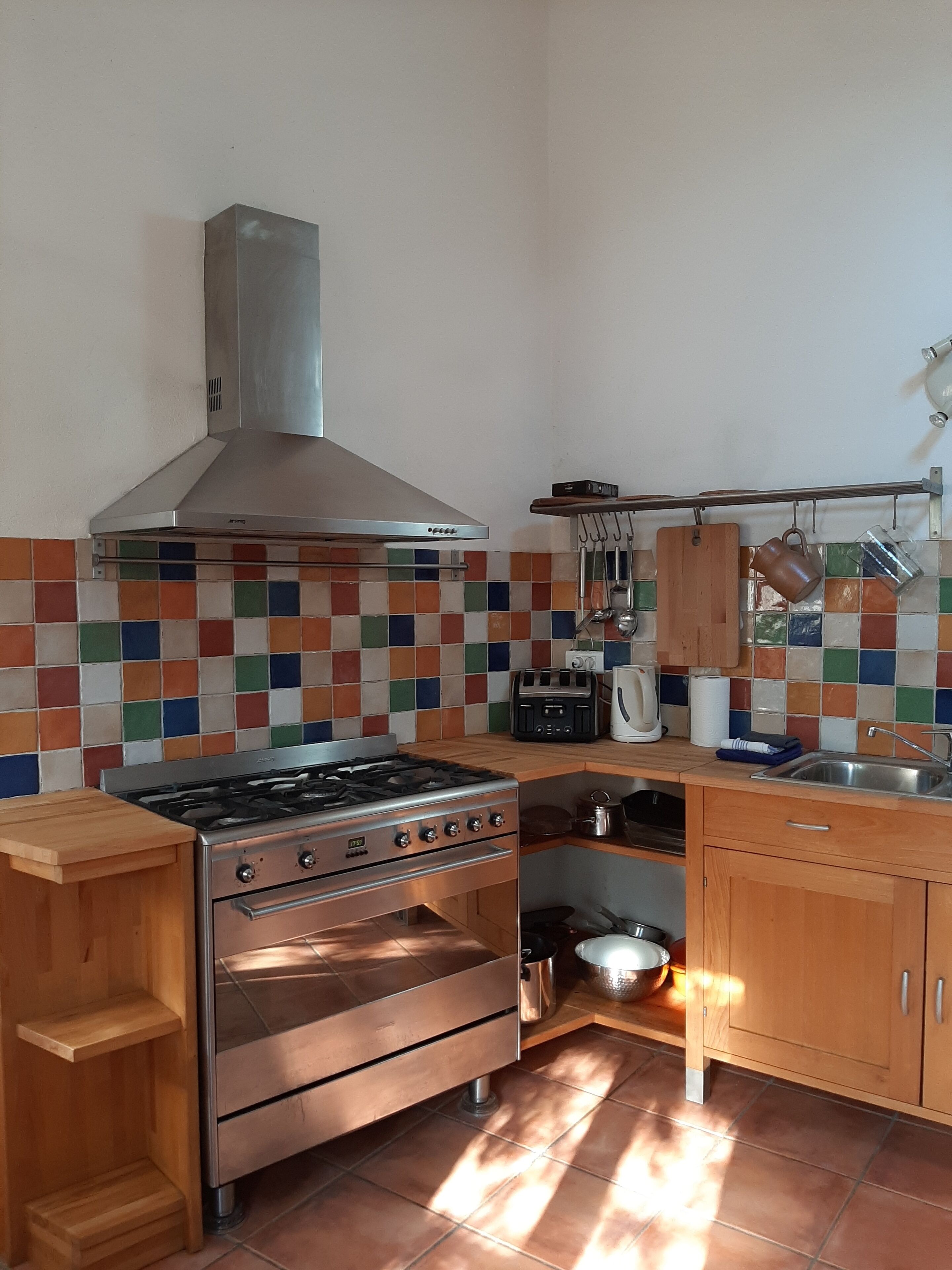 Una cucina con piano cottura a gas, forno e schienale piastrellato.