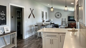 A modern kitchen with white cabinetry, a large island, and pendant lighting. - Serenity awaits at this secluded riverfront property (Muscoda)