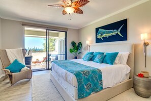 Relax in a serene bedroom with a large bed, ceiling fan, and wall art, offering a peaceful retreat.