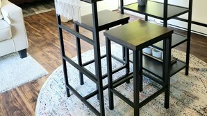 Een moderne woonkamer met een donker houten tafel, een witte deur en uitzicht op het omliggende landschap.