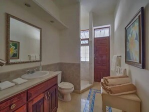 Een badkamer met een grote spiegel, een wastafel, een toilet en een handdoekrek.
