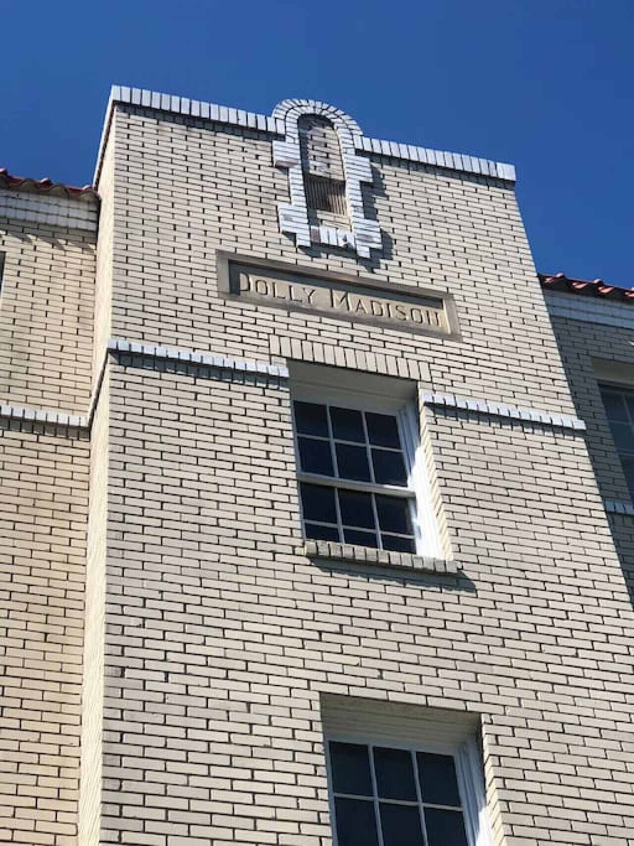 Een gebouw met een bakstenen gevel en een bord waarop 