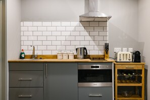 Enjoy cooking in this well-equipped kitchen with a stainless steel range hood, oven, and dishwasher.