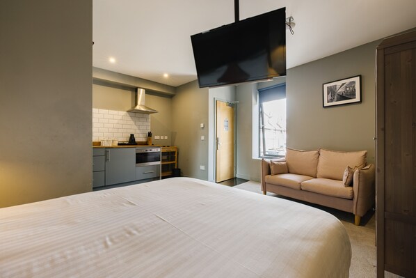Relax in this spacious room with a large bed, kitchenette, and comfortable seating area.