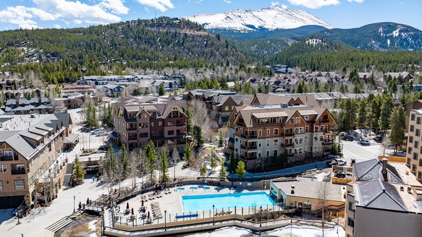Un complexe hôtelier doté d’une grande piscine, de plusieurs bâtiments et offrant une vue sur les montagnes.