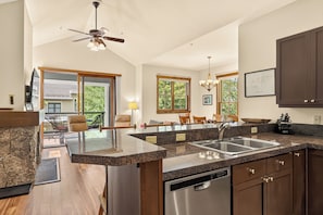 A spacious kitchen with granite countertops, a dishwasher, and wooden cabinets.